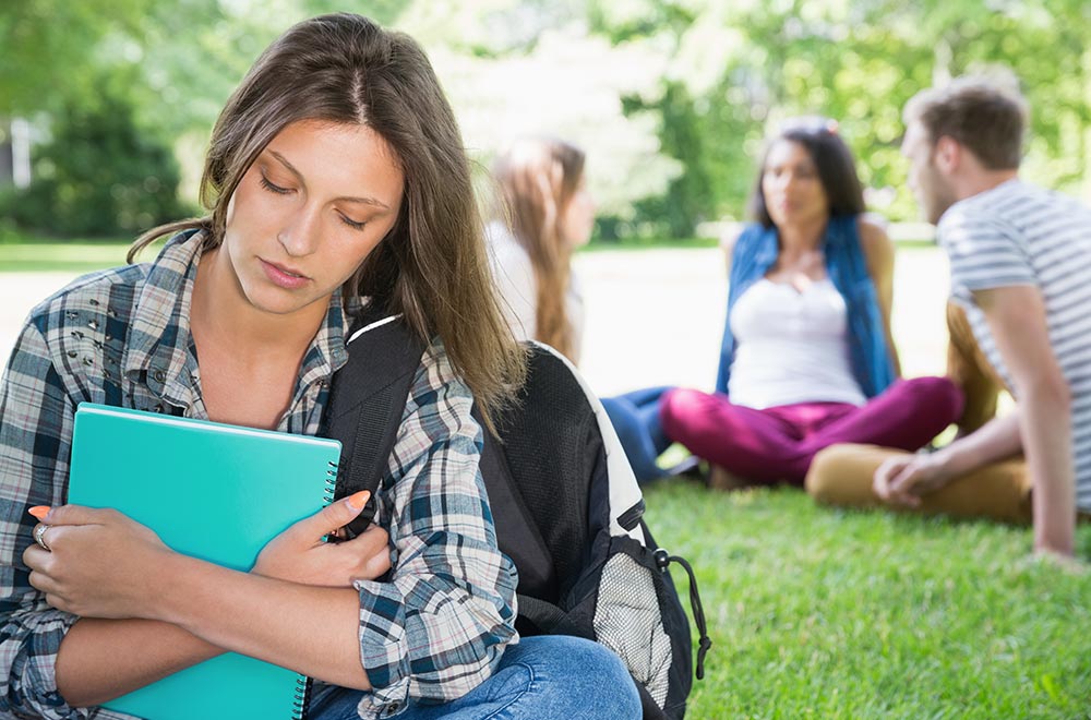 A female college student is walking outside looking overwhelmed. She is hoping to soon begin counseling for college students in Birmingham, AL with Empower Counseling soon.