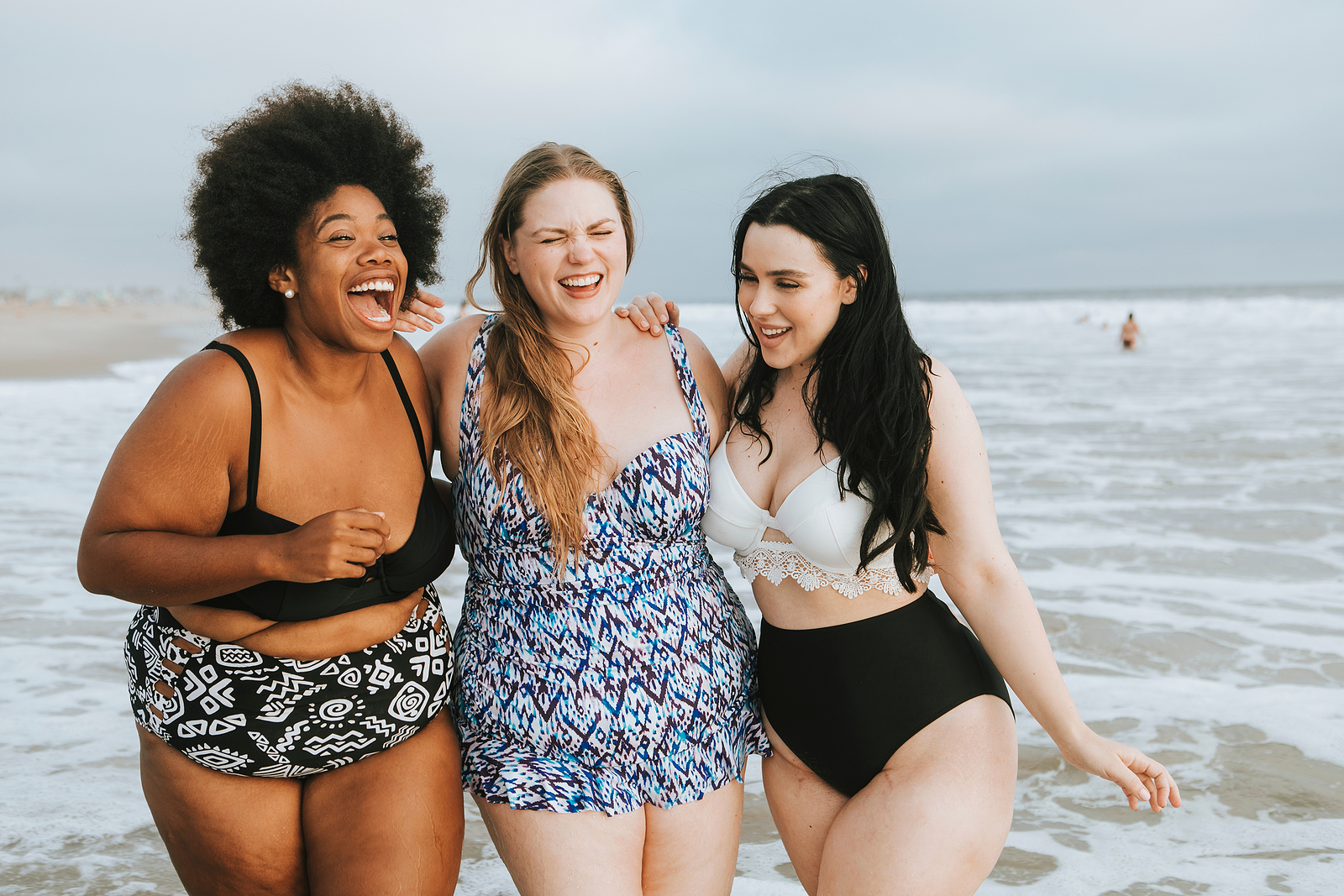 Three women laugh together while walking through the ocean. They are feeling better after starting counseling for college students with Empower Counseling through online therapy in Auburn, AL.