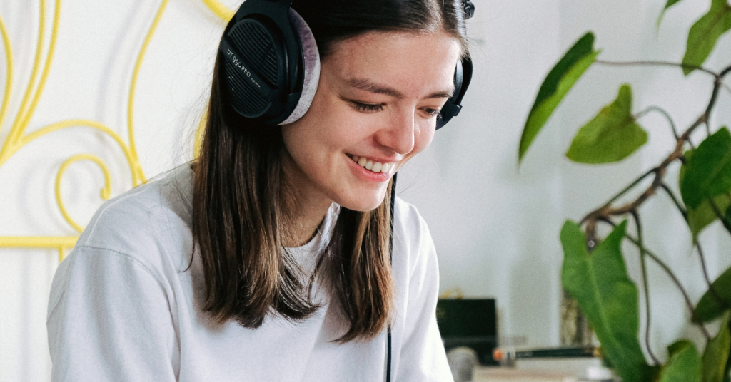 Girl smiling and listening to music on headphones after ACT therapy for anxiety with empower counseling
