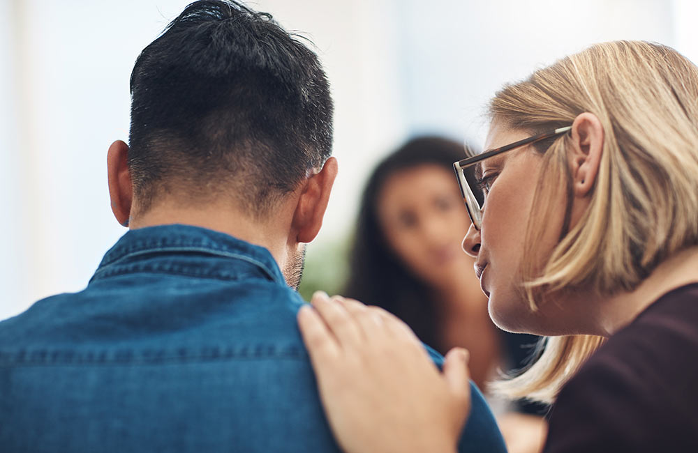Image of a person patting another's back with their hand. This image depicts the support from a substance abuse counselor in Birmingham, AL. 35401