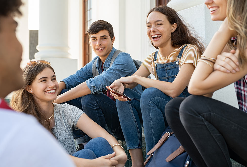 Image of a group of friends sitting together and smiling. This image depicts how you may feel after meeting with a therapist in Birmingham, AL like Kristine. | 36849
