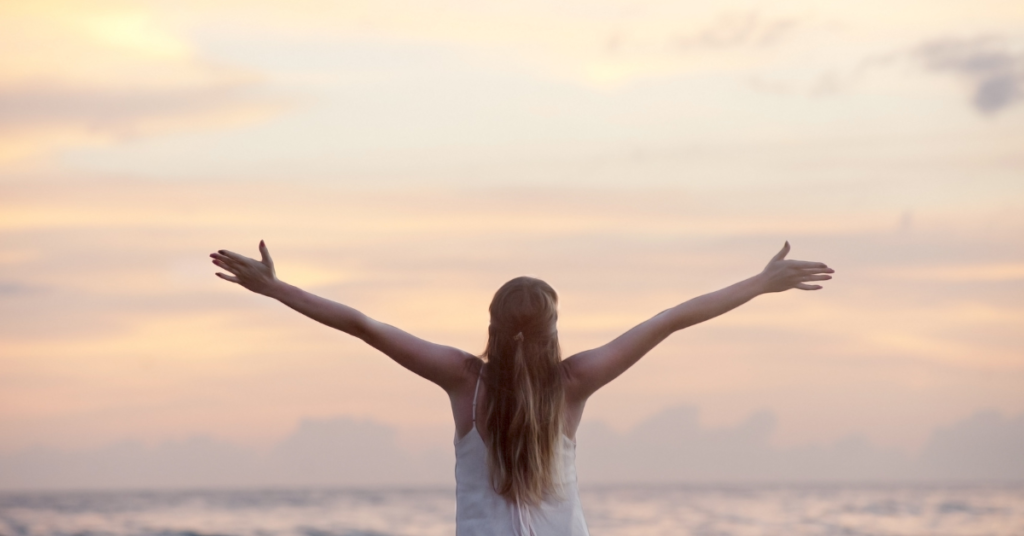 woman with open arms facing ocean after anxiety counseling Empower Counseling Birmingham Alabama