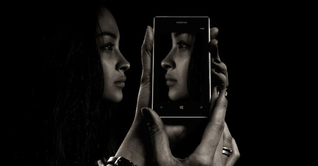 a woman with reflection in phone/ self image counseling/ acceptance commitment therapy for depression counseling empower counseling/ birmingham alabama/ 35223 35216 35209