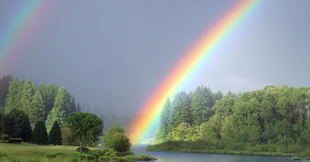 a rainbow over water with trees/ trauma therapy/ empower counseling Birmingham/ 35216 35223 35209