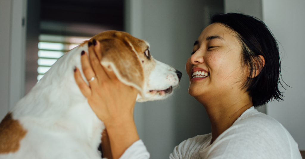 a young woman smiling and petting dog after anxiety therapy