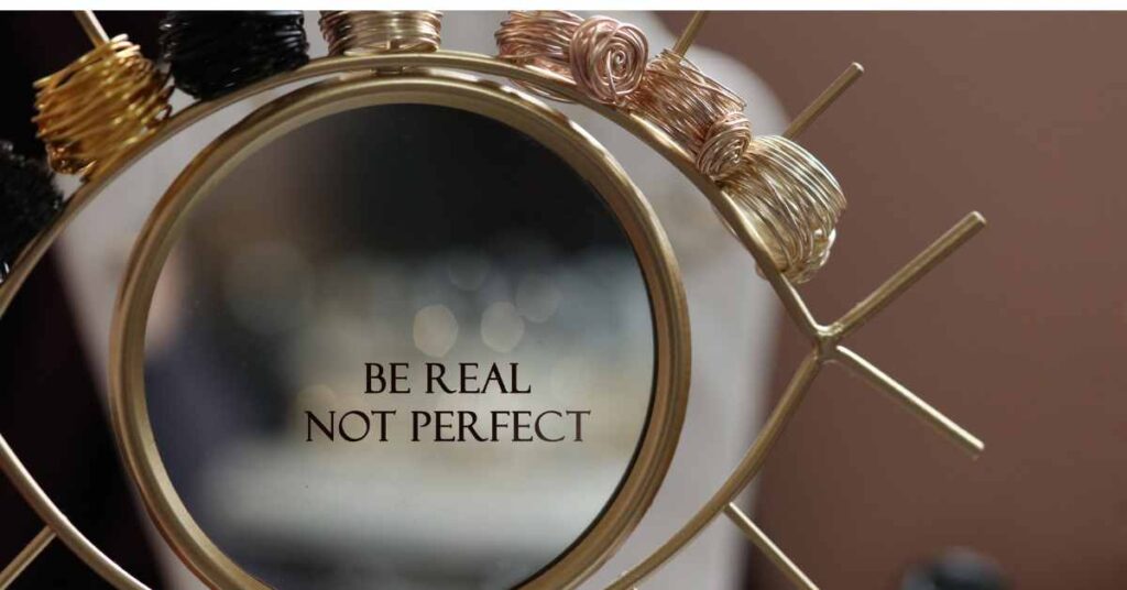 a sculpture of an eye with a mirror on it reading be real not perfect