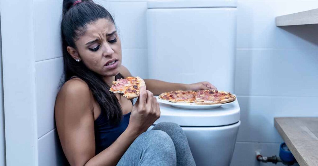 Woman binge eating pizza/ eating disorder therapy needed/ Empower Counseling