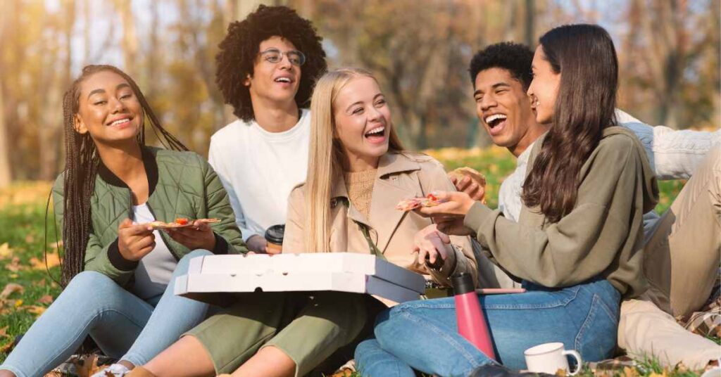 Friends laughing and eating pizza
