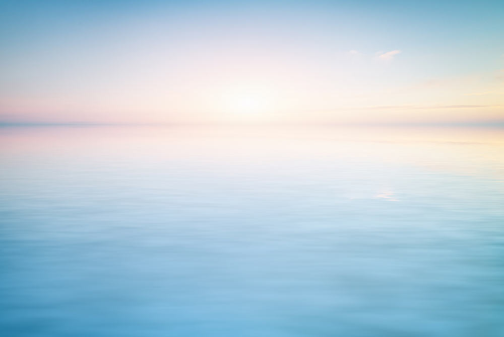 Image of peaceful calm blue water with a pink sky. Work with an EMDR therapist in Birmingham, AL to cope with your past trauma in healthy ways.
