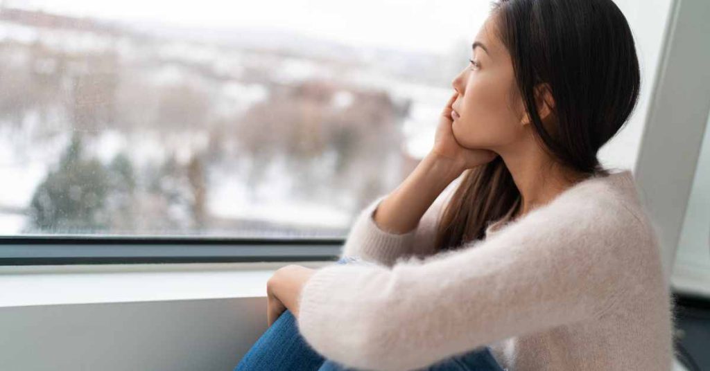 a woman looking out the window on a snowy day