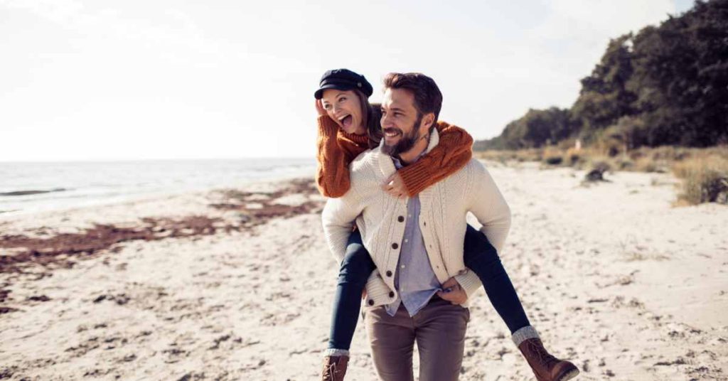 a happy couple on the beach/ premarital therapy/ online in Alabama/ Empower Counseling
