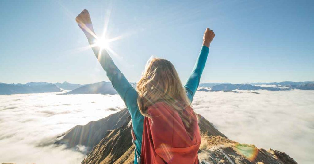 a woman who accomplished her goal of reaching the top of a mountain/ stop procrastination/ reach goals/ Empower Counseling/ Birmingham Al.
